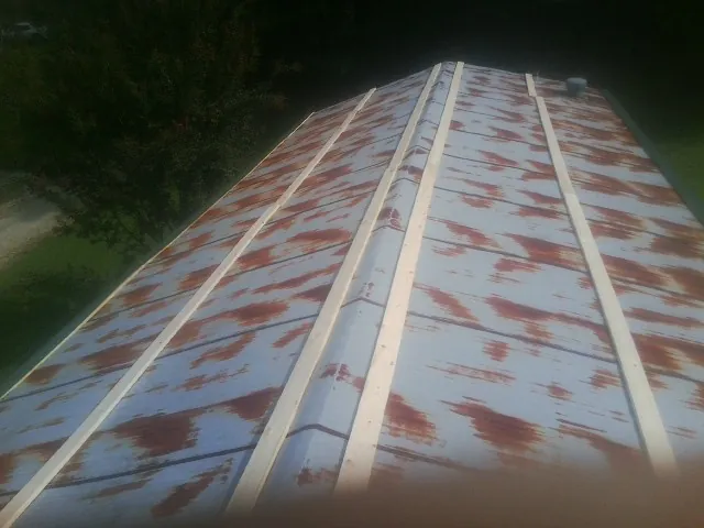 Rusted metal roof panels with new wood purlins before replacement — Storm Damage Roof Repair in Corona by Roofing Brothers