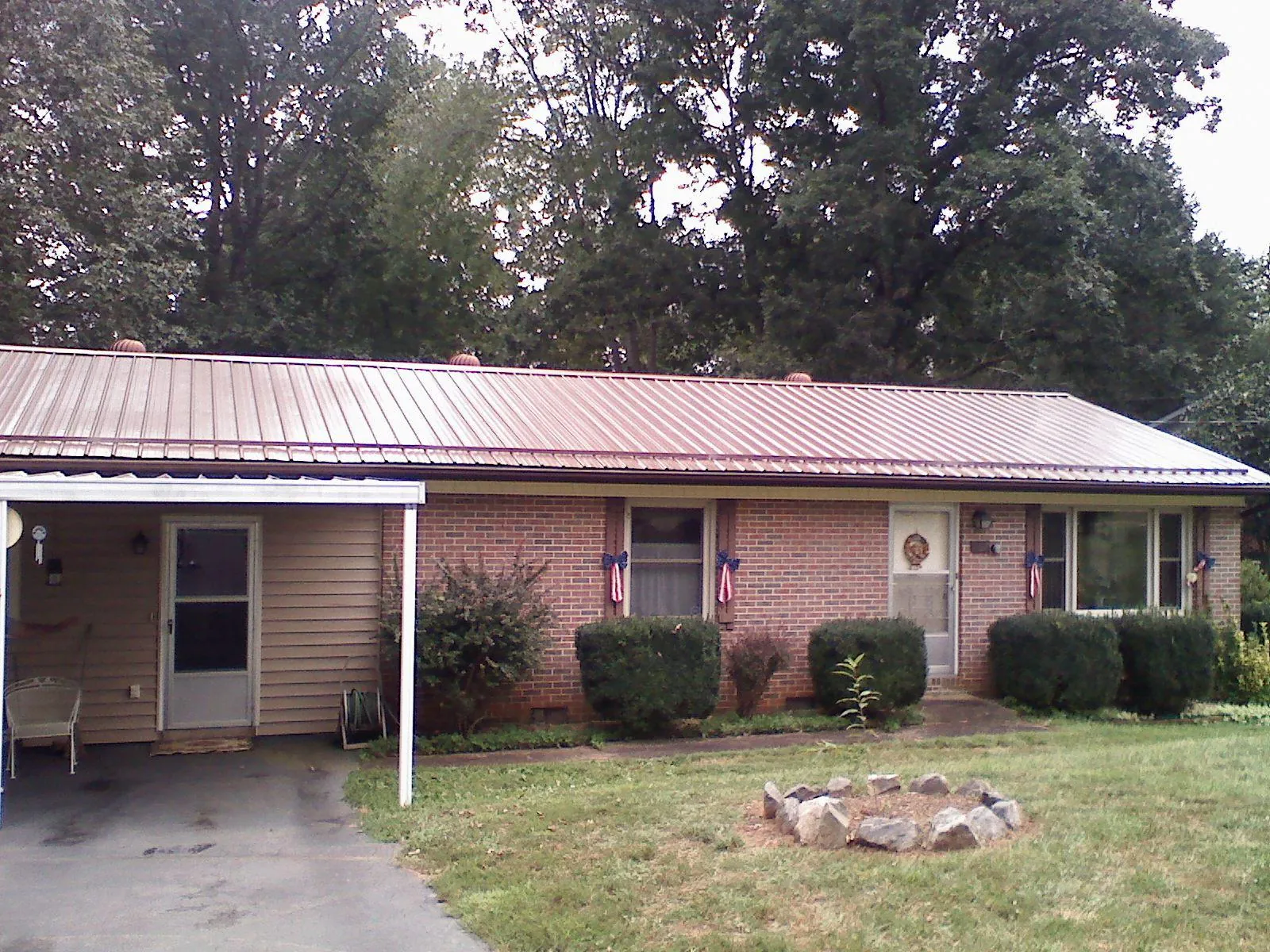 Bronze metal roof and carport on a brick ranch home — Roof Repair work by our crew in Corona
